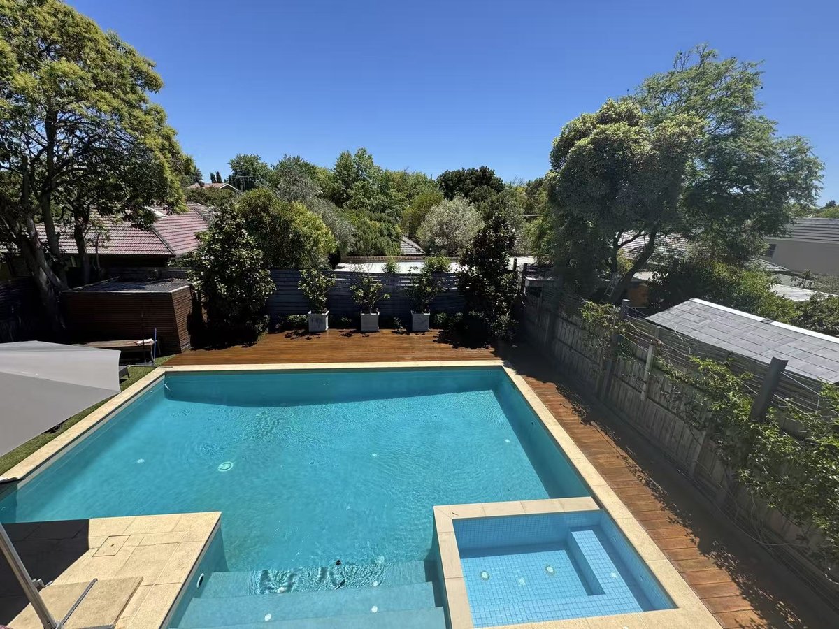 Weathered poolside deck before restoration, with faded and greyed timber