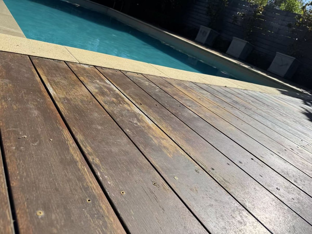 Close-up of the faded deck dropped below the sandstone coping