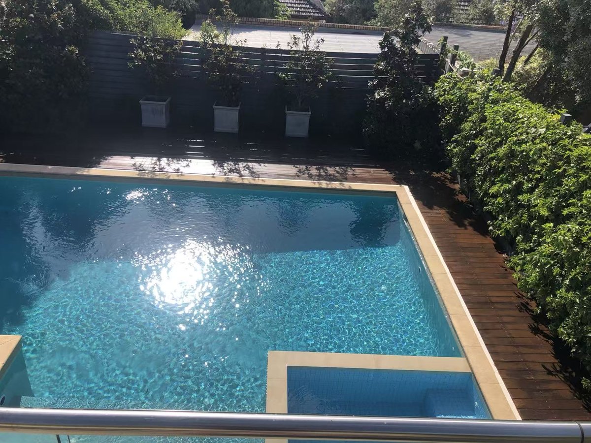 Completed deck flush with the pool coping, with a deep, even stain