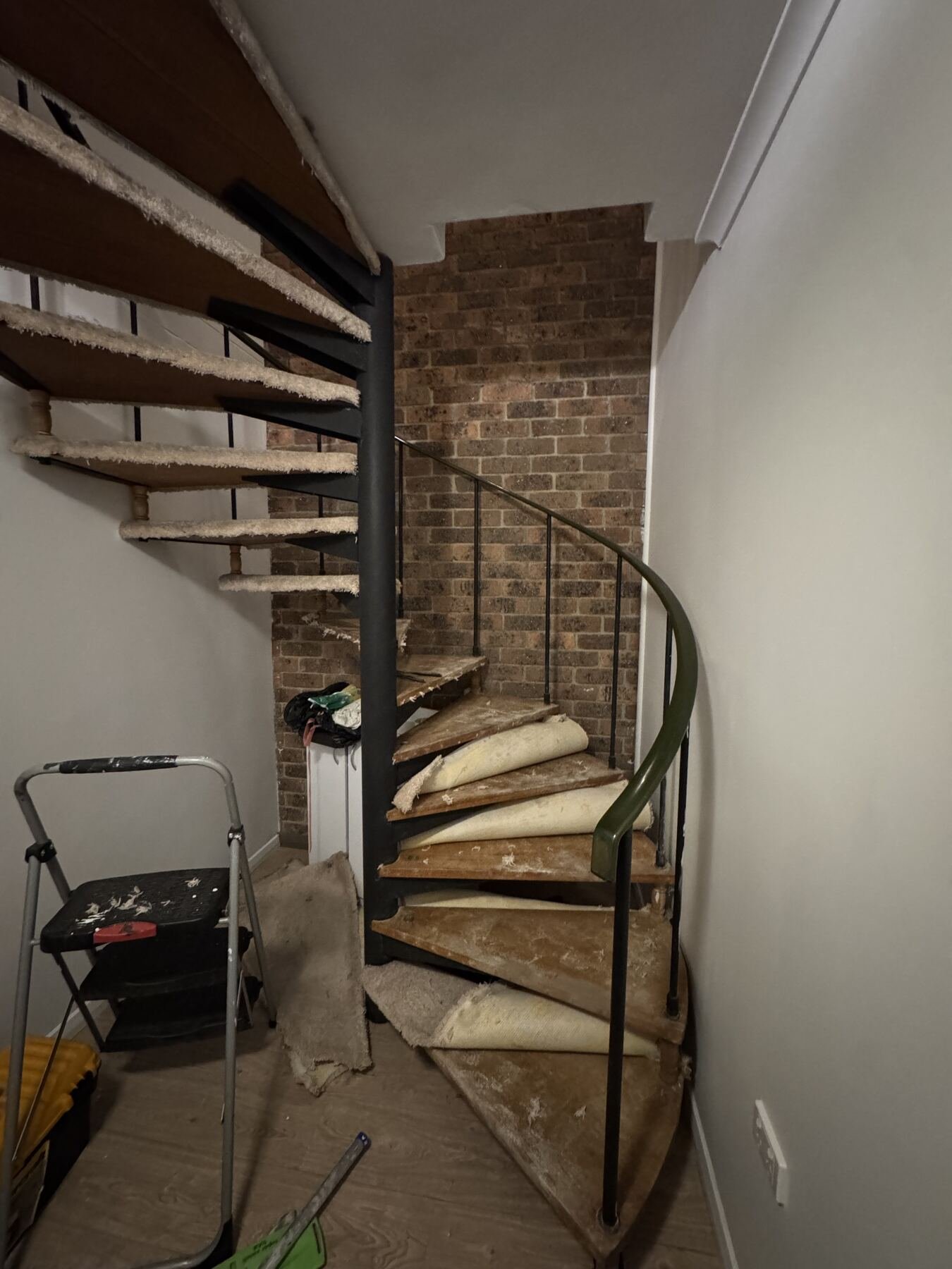 Original spiral staircase with worn carpet still on the timber treads before work began