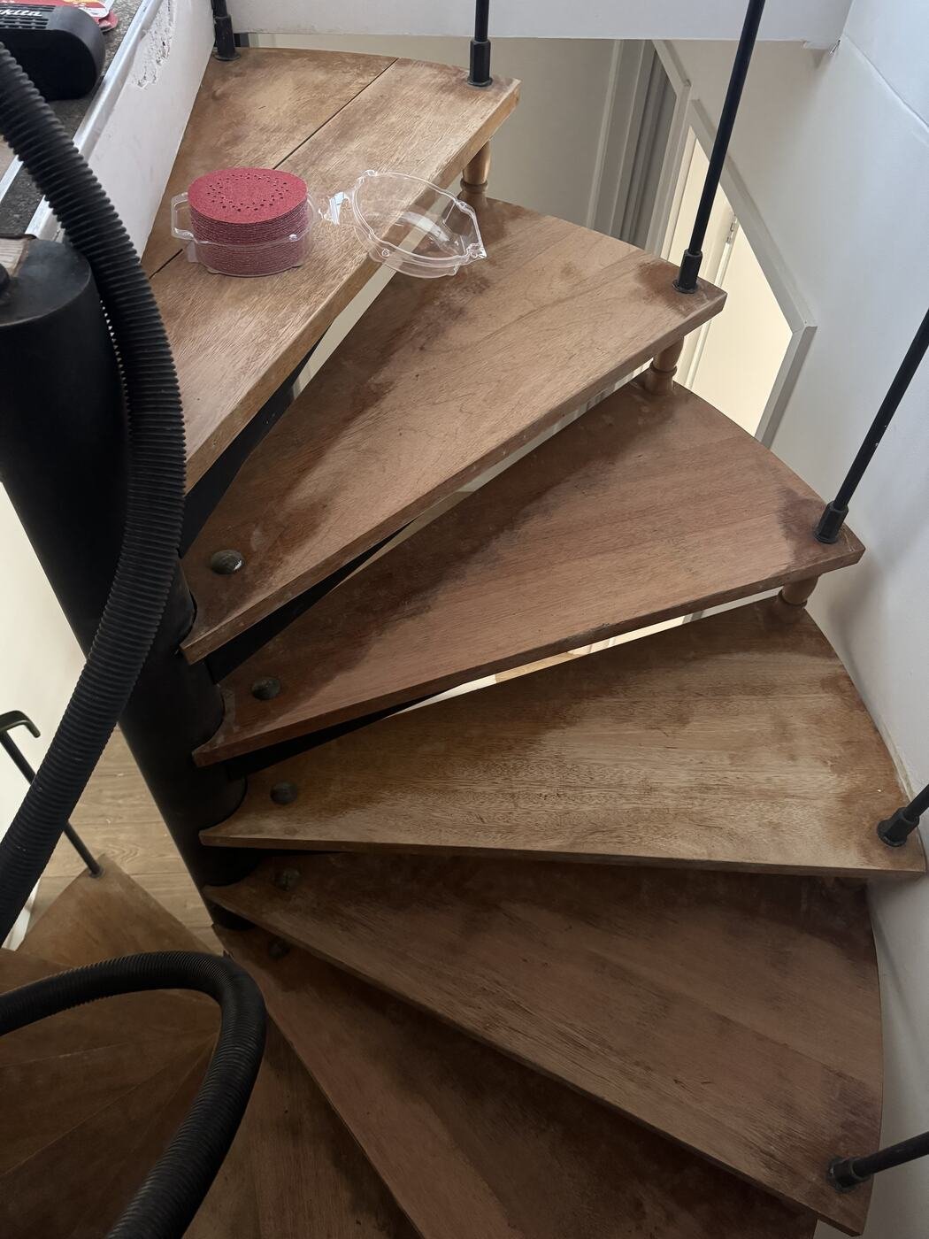 Spiral staircase treads being sanded back to bare timber