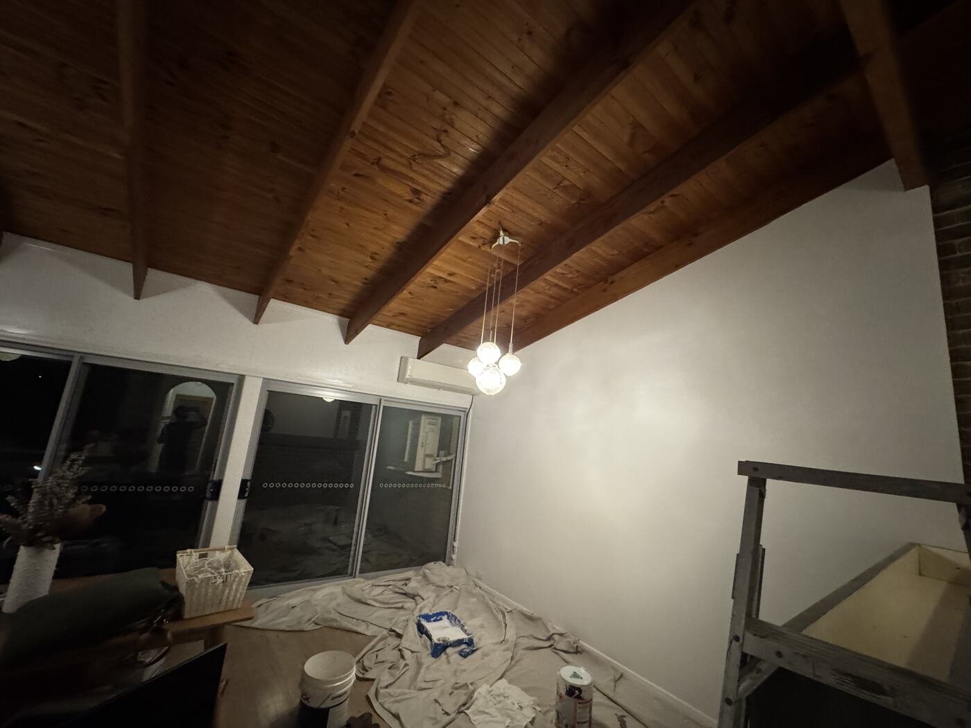 Repaint in progress across the living space with drop sheets covering the floor