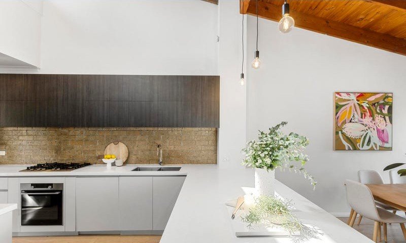 Kitchen with gas cooktop, oven and dark upper cabinetry