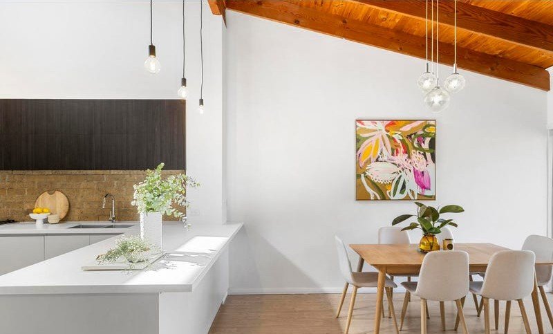 Kitchen benchtop and dining area with a bright, styled finish