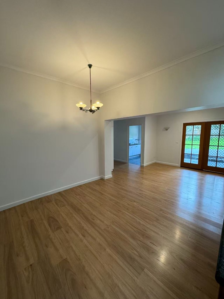 Completed open-plan dining and living space with fresh paint and timber flooring