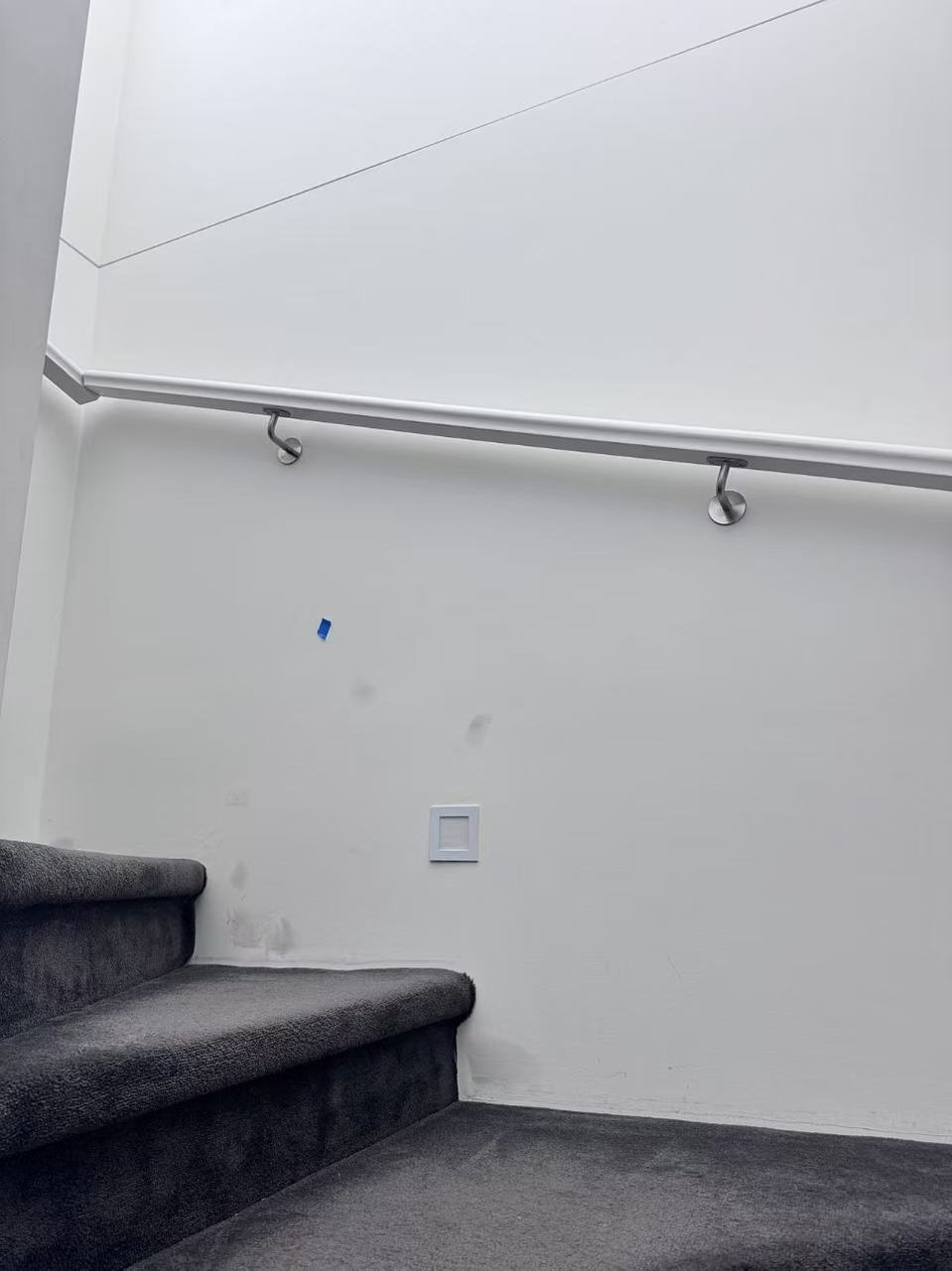 Caulfield pre-auction paint touch-ups — high stairwell void wall patched around the handrail