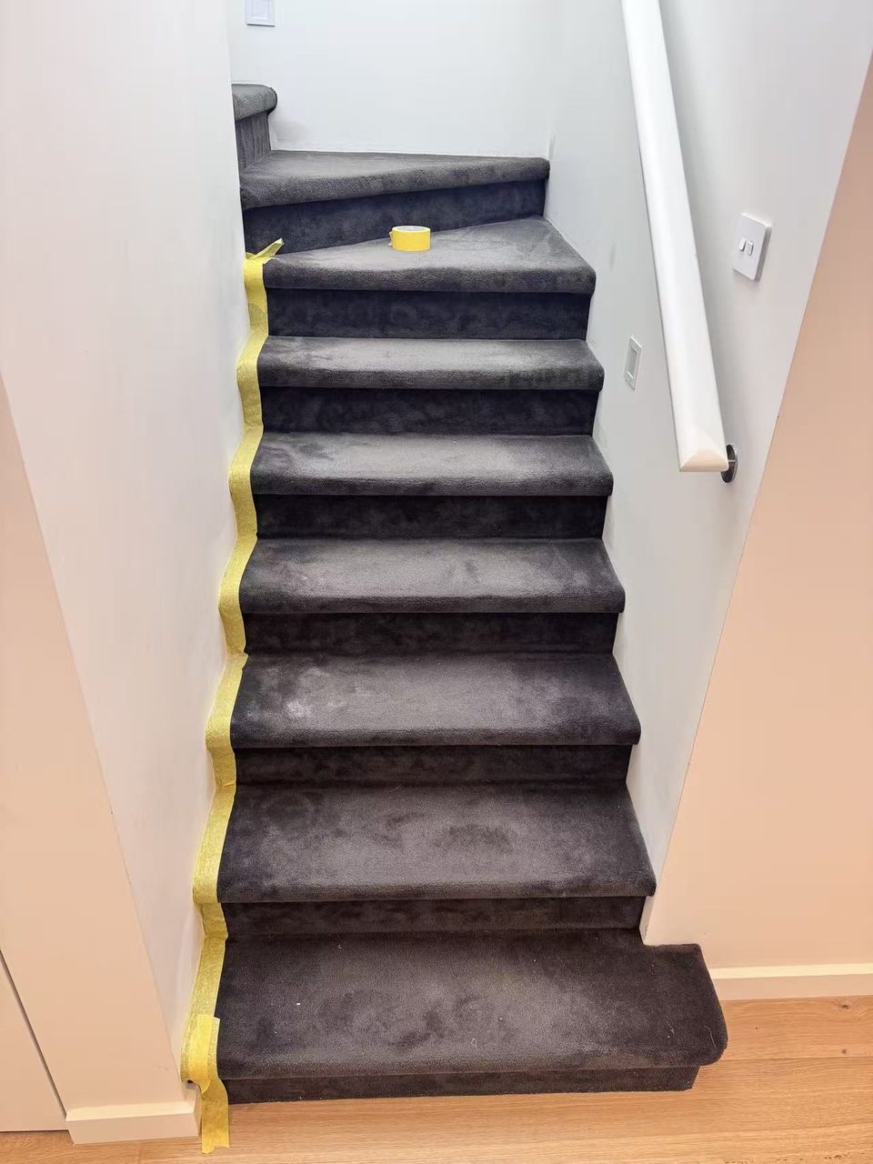 Caulfield pre-auction paint touch-ups — stair edges masked with tape for clean cut-in lines