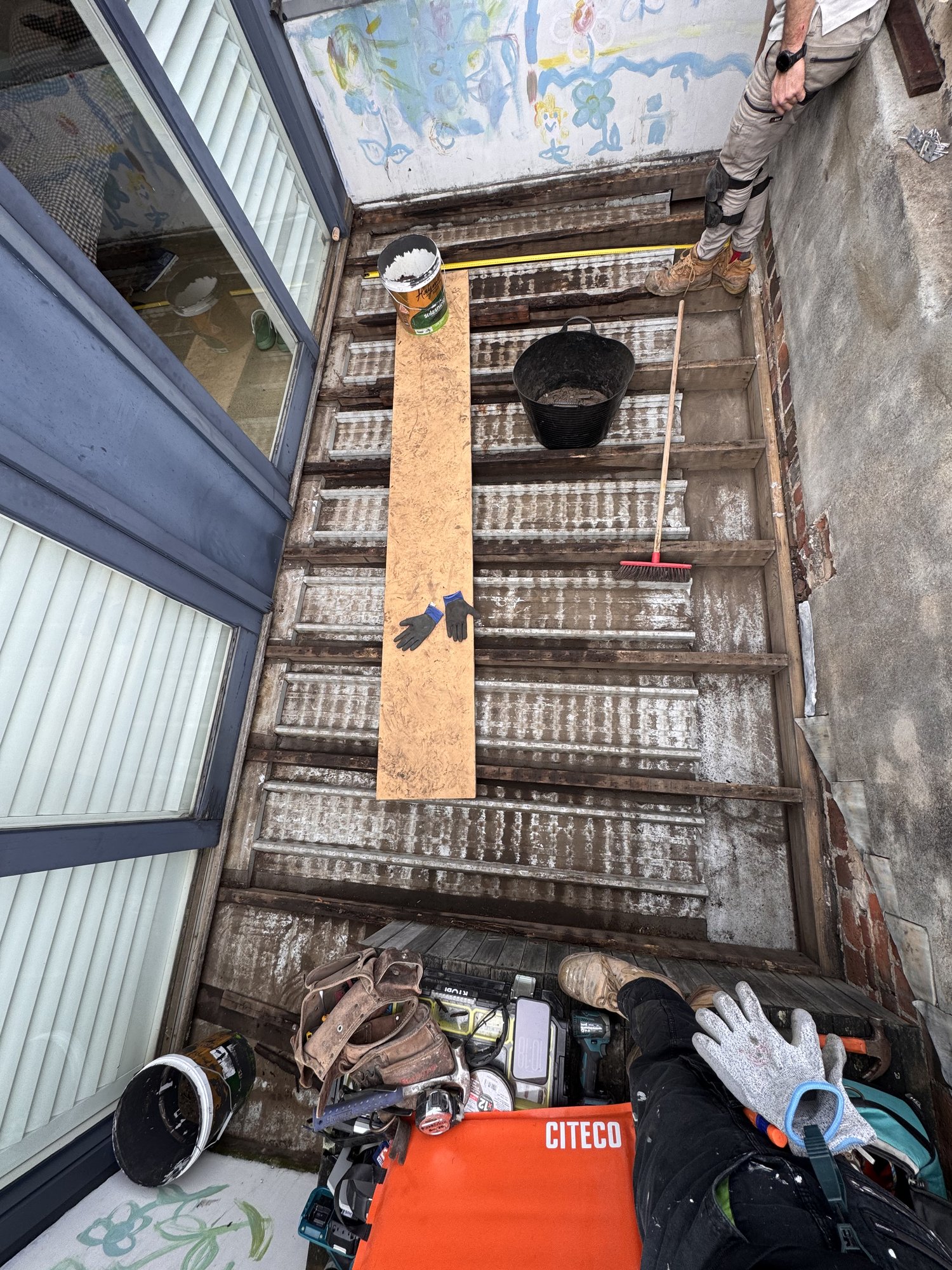 Measuring up the cleared rooftop deck before rebuilding