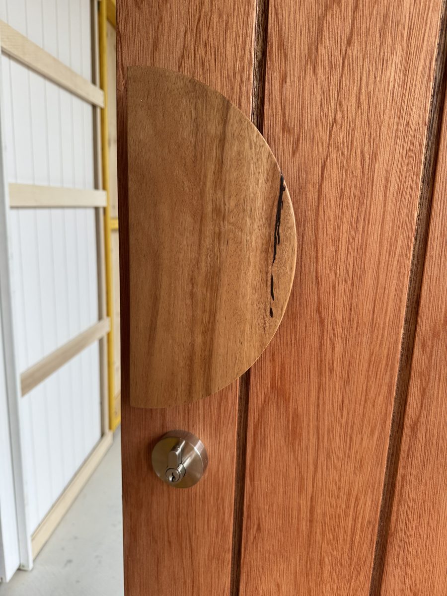 Close-up of the half-moon timber handle and deadbolt